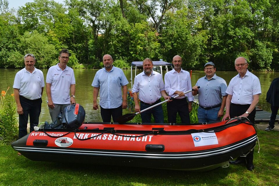 Sieben Personen stehen an einem Schlauchboot